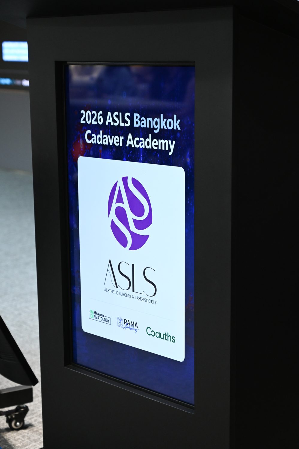 Màn hình sự kiện 2026 ASLS Bangkok Cadaver Academy với logo ASLS, RAMA Dermatology, RAMA Anatomy và Coauths